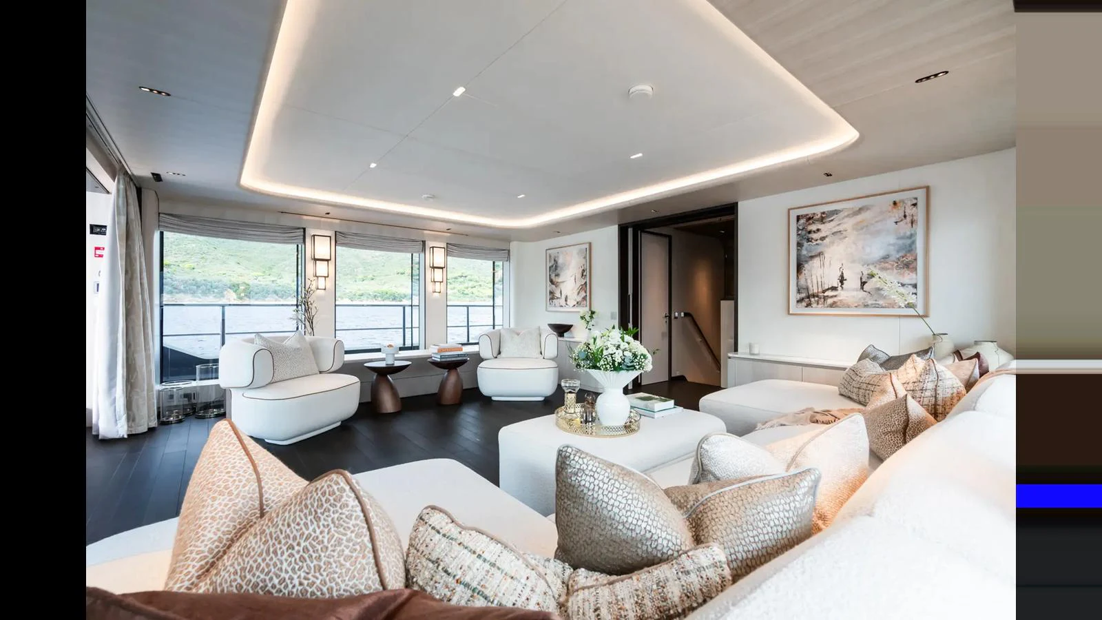 The salon features elegant seating with panoramic views and tasteful decor. aboard BIG SHARK Yacht for Sale