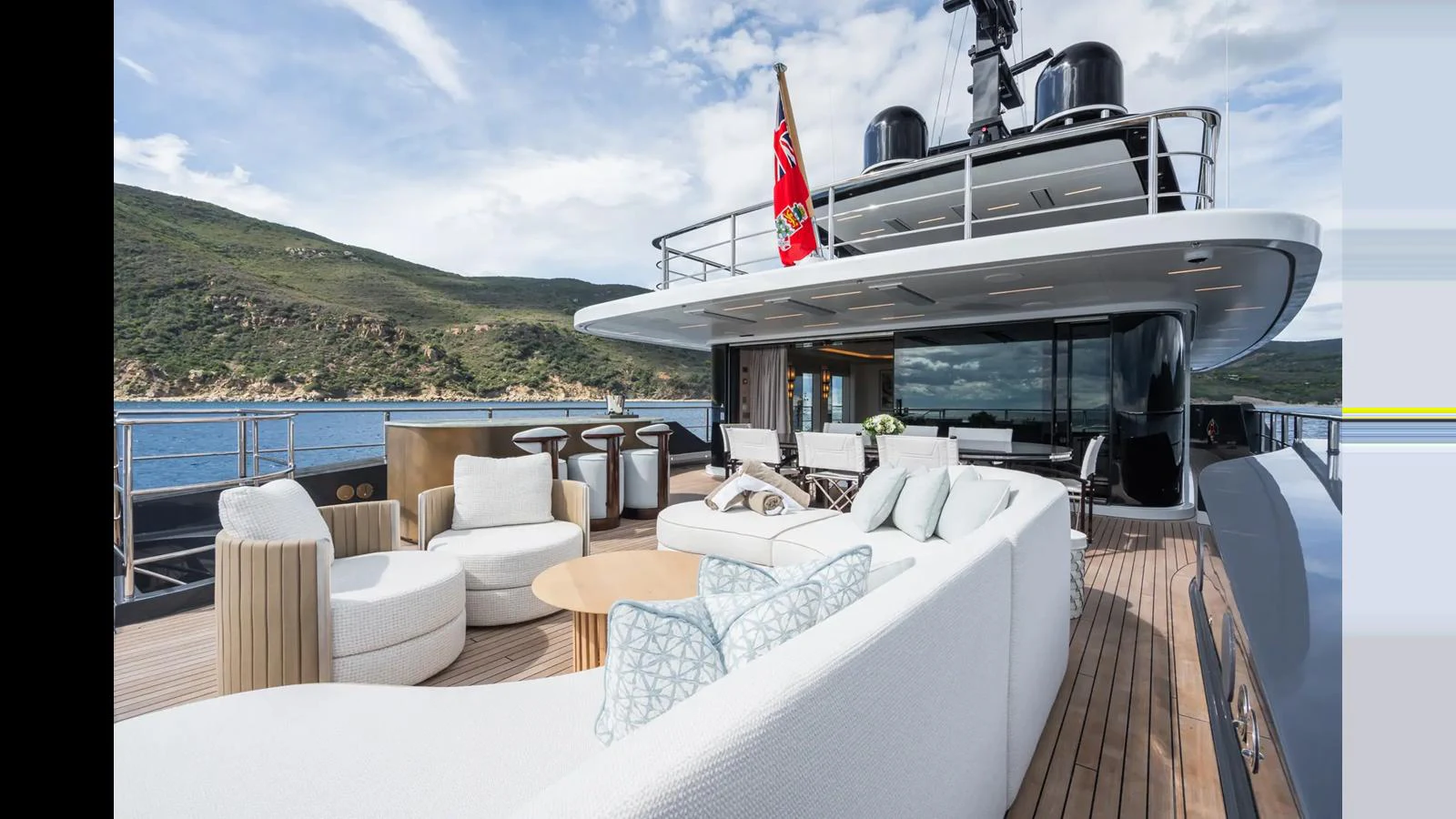 The aft deck features luxurious seating arrangements with stunning views of the surrounding landscape. aboard BIG SHARK Yacht for Sale