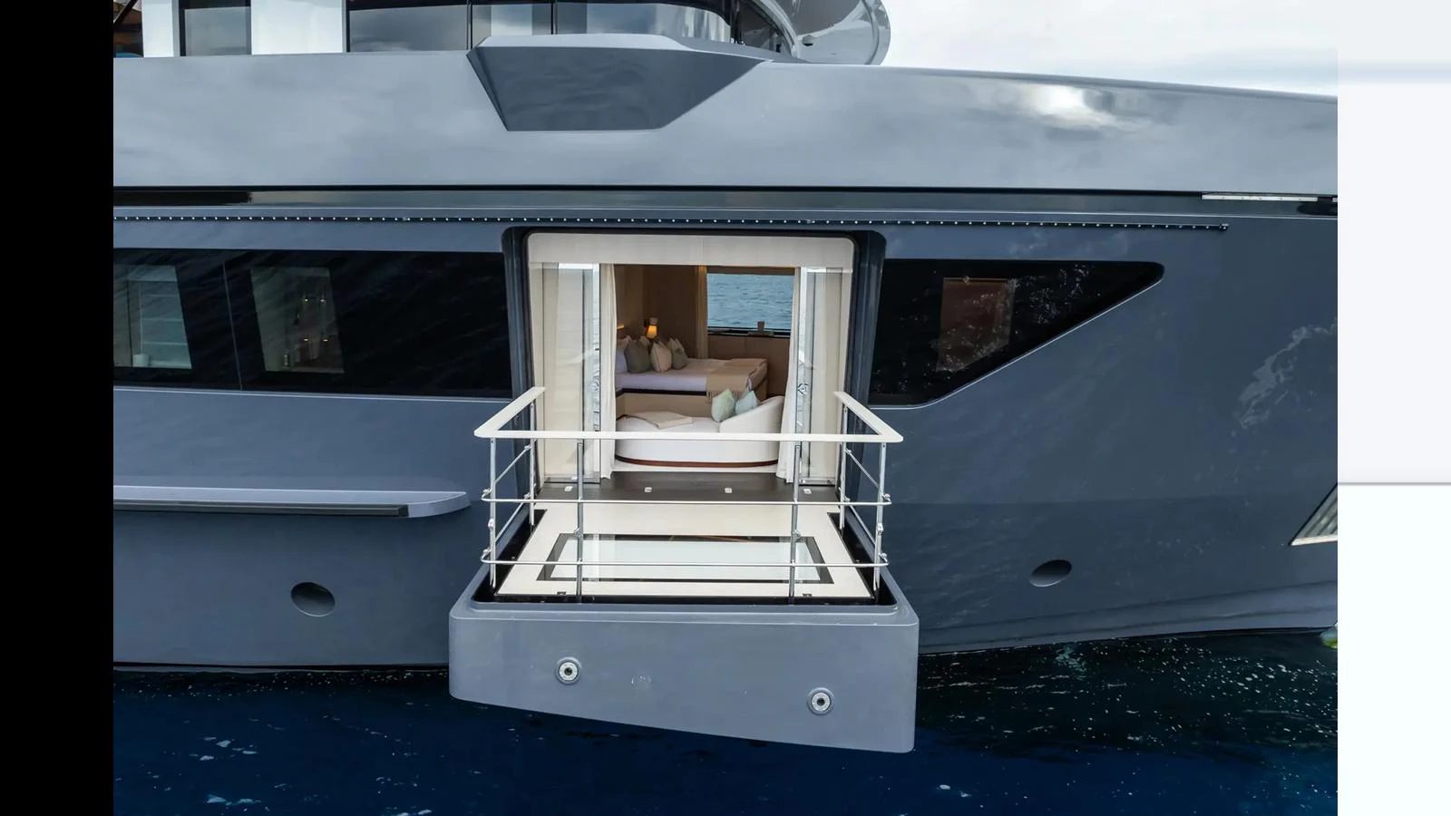 A luxurious yacht features a private balcony extending over the water, offering an intimate space to relax and enjoy the view. aboard BIG SHARK Yacht for Sale