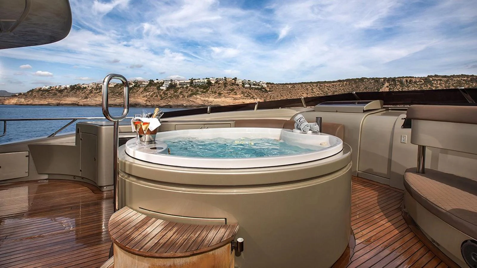 The sundeck features a luxurious hot tub with a stunning view of the coastline. aboard YCM 120 Yacht for Sale
