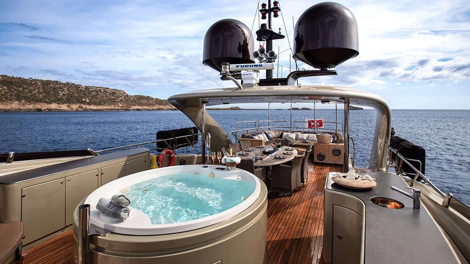 The sundeck features a luxurious hot tub and a spacious lounging area with stunning ocean views. aboard YCM 120 Yacht for Sale