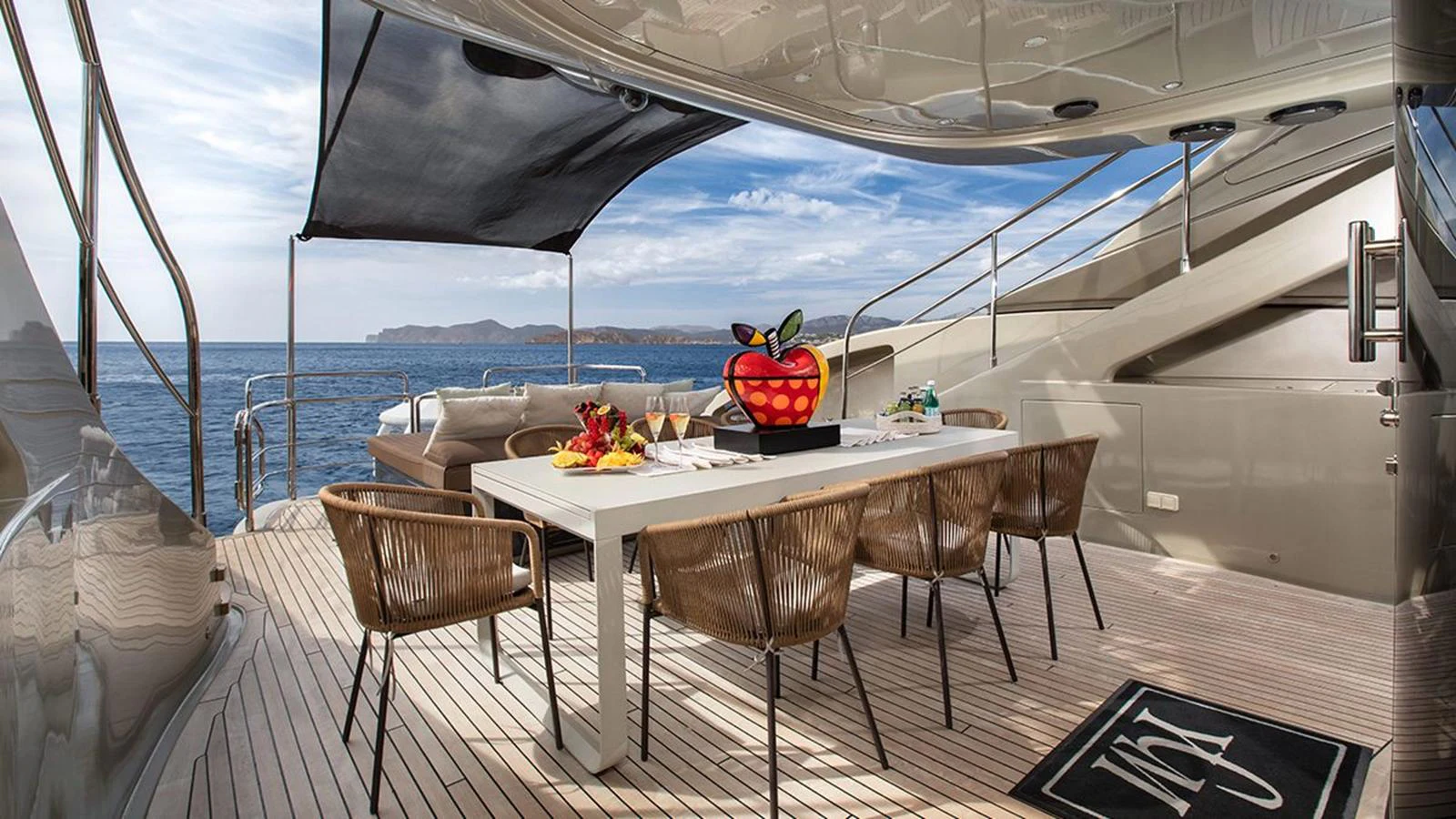 The aft deck features a stylish dining area with a modern table and comfortable chairs, perfect for alfresco meals with a view. aboard YCM 120 Yacht for Sale