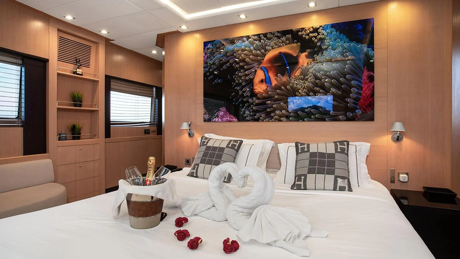 The master stateroom features a luxurious bed with elegant decor and a vibrant underwater-themed artwork above the headboard. aboard YCM 120 Yacht for Sale