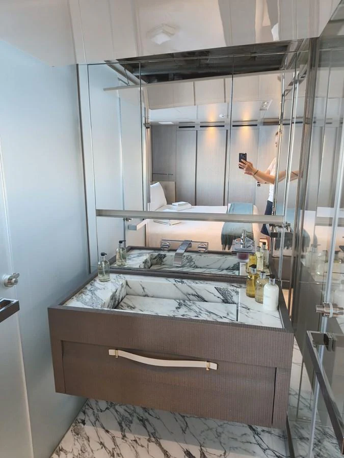 A luxurious yacht bathroom featuring a sleek marble sink and modern fixtures. aboard HONEY Yacht for Sale