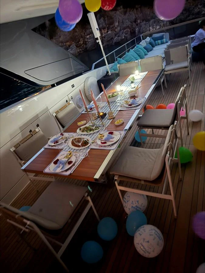 An elegant dining setup on the aft deck, perfect for entertaining guests. aboard HONEY Yacht for Sale