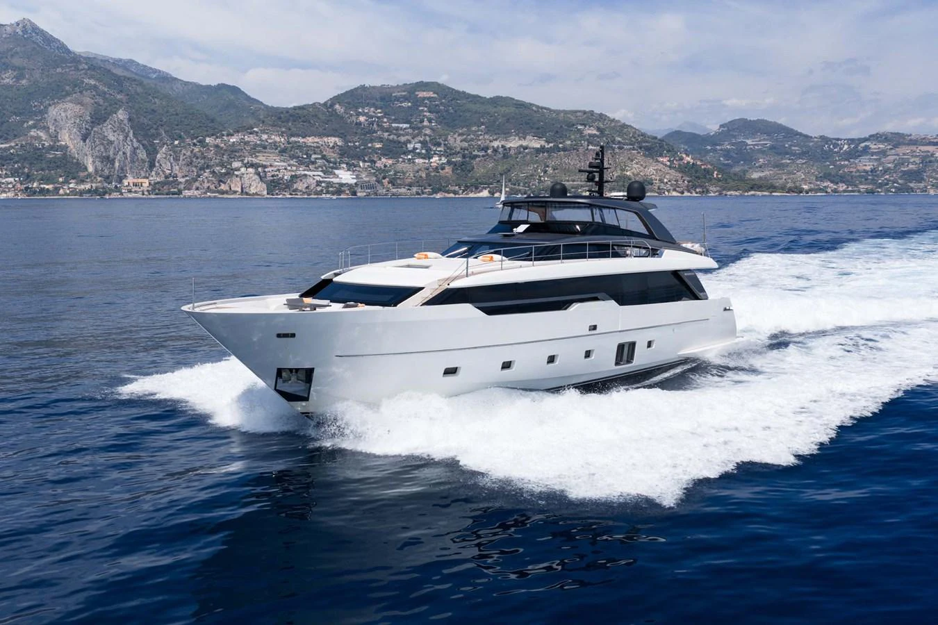 A sleek and modern yacht cruises through the water with a stunning coastal backdrop. aboard JACKI 8 Yacht for Sale