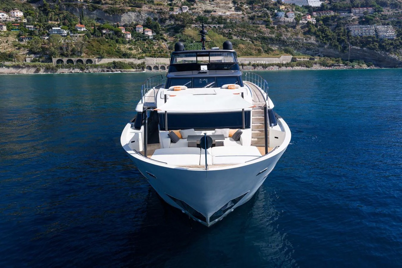 A sleek yacht is anchored in calm waters with a scenic coastal backdrop. aboard JACKI 8 Yacht for Sale