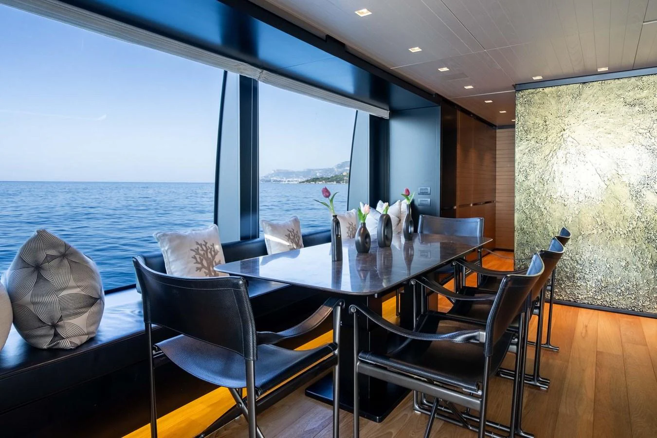The yacht's dining area offers a stunning view of the sea through large windows. aboard JACKI 8 Yacht for Sale