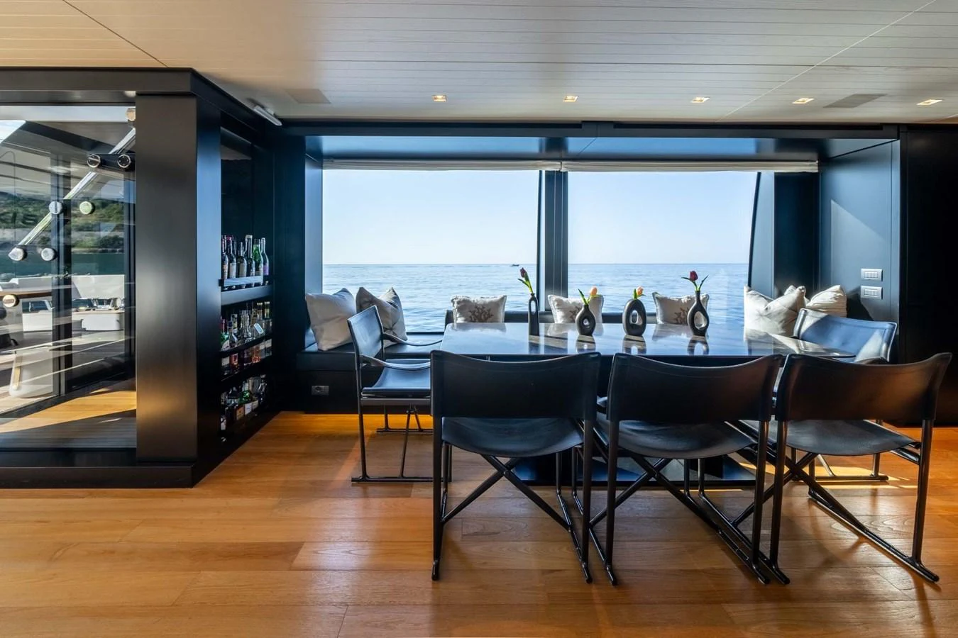 The yacht's dining area features a sleek table with a stunning view of the sea through large windows. aboard JACKI 8 Yacht for Sale