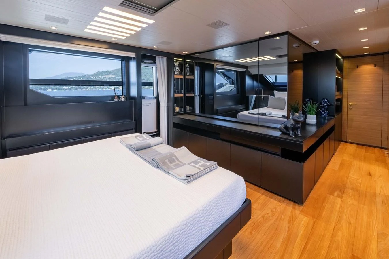 The master stateroom features a luxurious bed, ample storage, and large windows with scenic views. aboard JACKI 8 Yacht for Sale