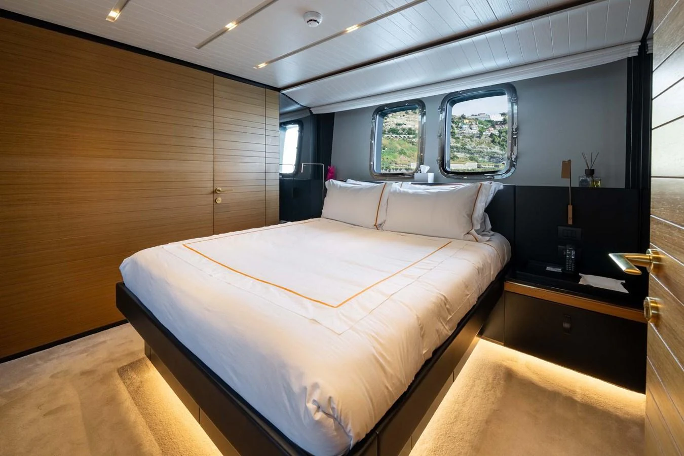A luxurious stateroom featuring a large bed with elegant bedding and ambient lighting. aboard JACKI 8 Yacht for Sale