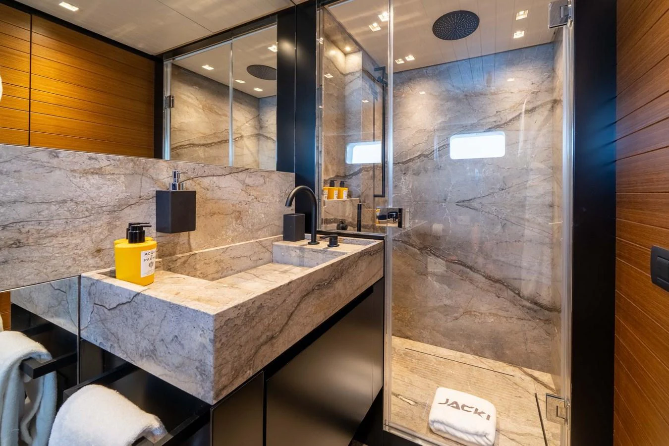 The yacht's bathroom features a luxurious stone sink and a spacious glass-enclosed shower. aboard JACKI 8 Yacht for Sale