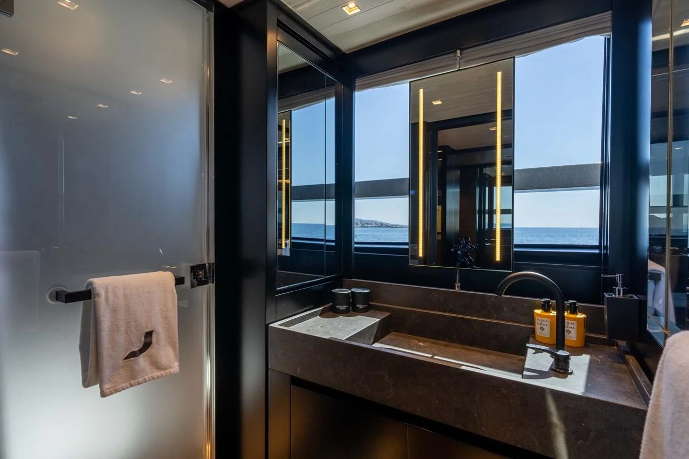 A sleek and modern yacht bathroom with a large mirror and ocean view. aboard JACKI 8 Yacht for Sale