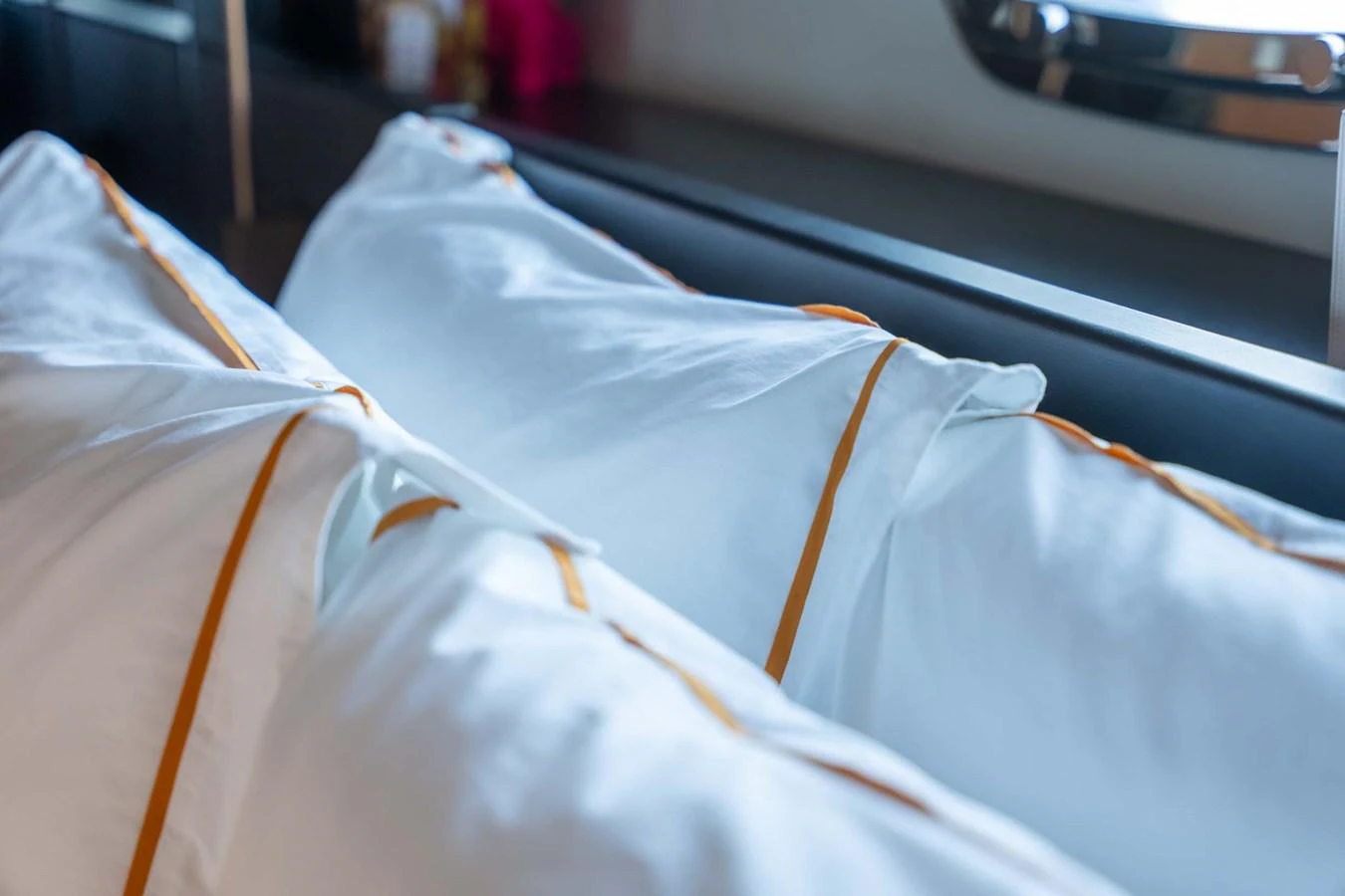 The image showcases a close-up of plush pillows with elegant trim on a yacht's interior. aboard JACKI 8 Yacht for Sale