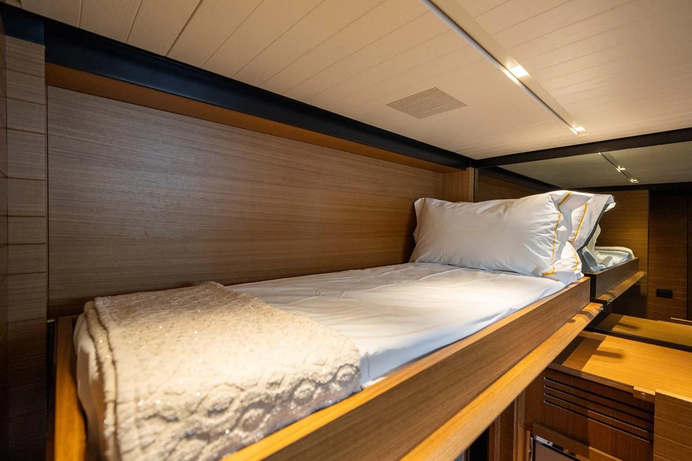 A cozy cabin with a single bed, featuring wooden paneling and soft lighting. aboard JACKI 8 Yacht for Sale
