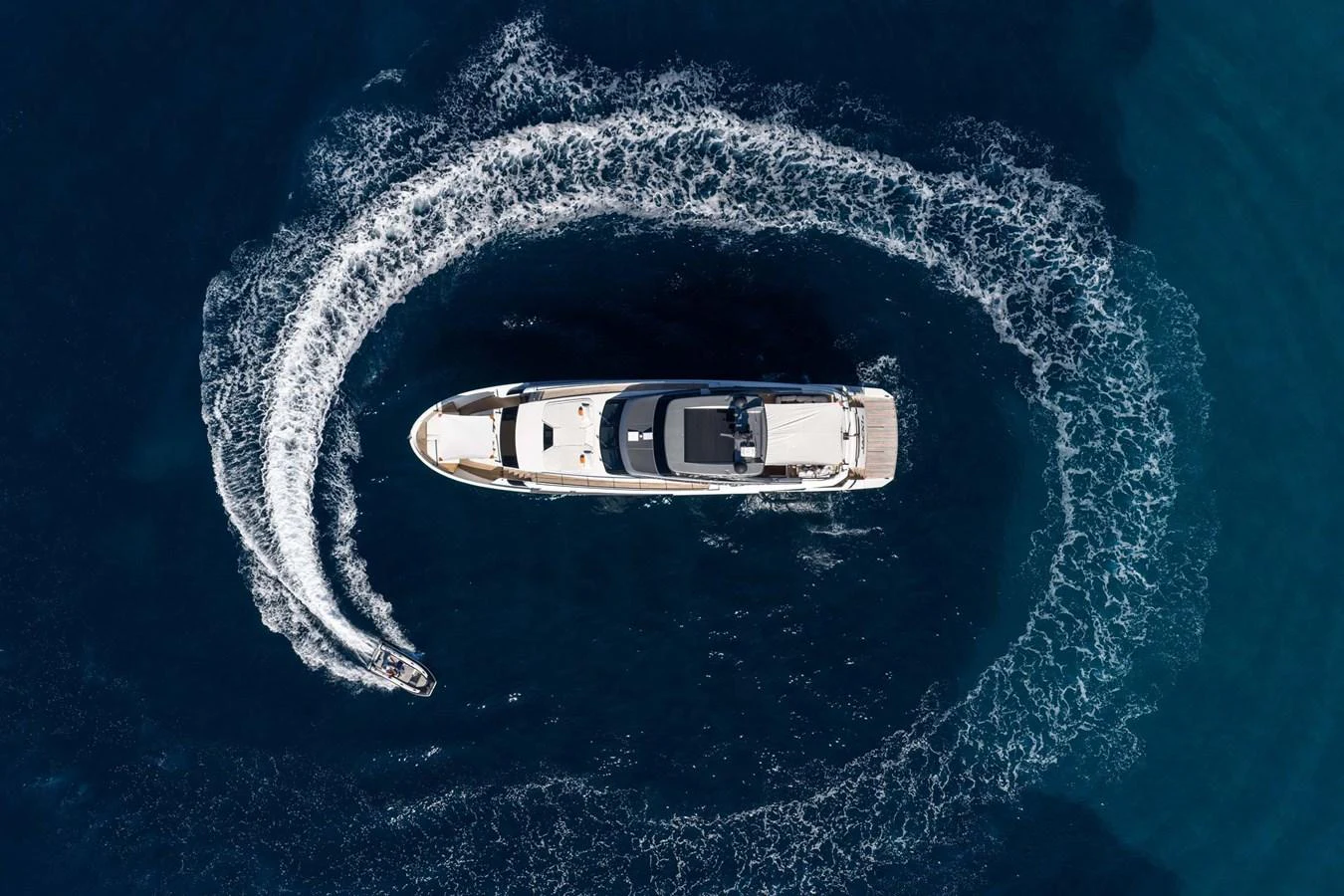 A stunning aerial view of a yacht cruising through deep blue waters, leaving a circular wake behind. aboard JACKI 8 Yacht for Sale