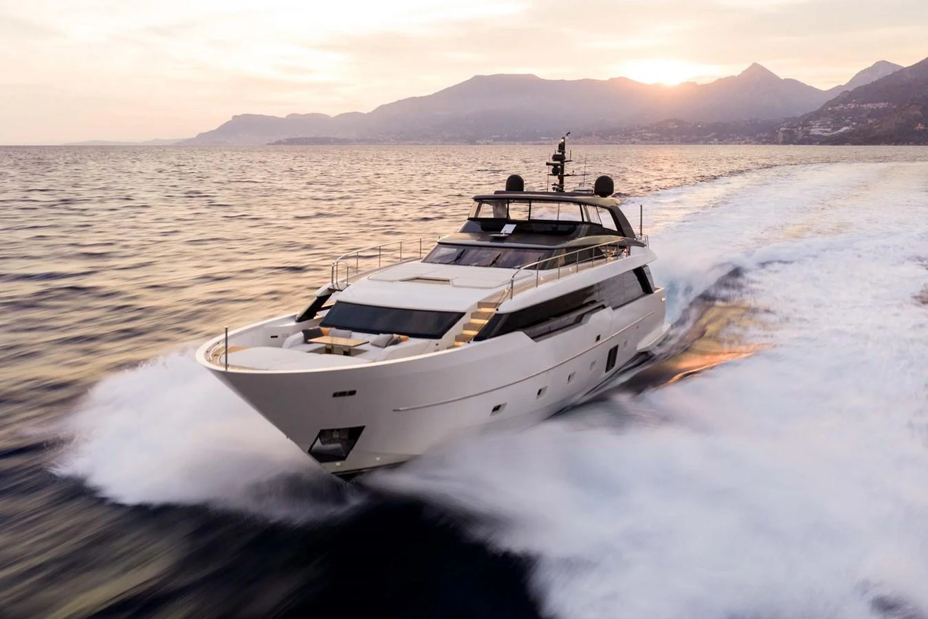 A sleek and modern yacht cruises swiftly across the water at sunset. aboard JACKI 8 Yacht for Sale