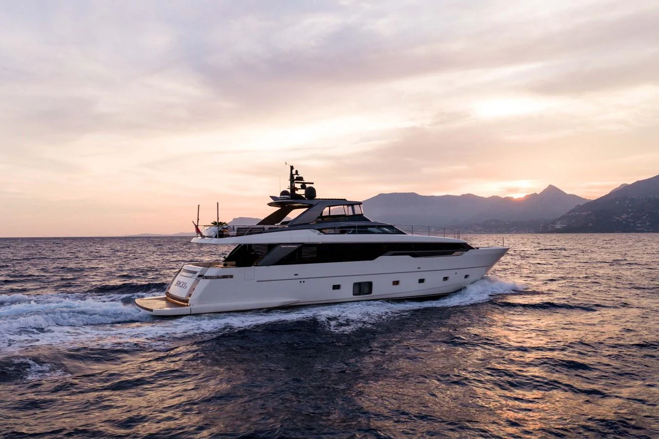 A sleek yacht cruises on the open water at sunset, showcasing its elegant design against a picturesque backdrop. aboard JACKI 8 Yacht for Sale