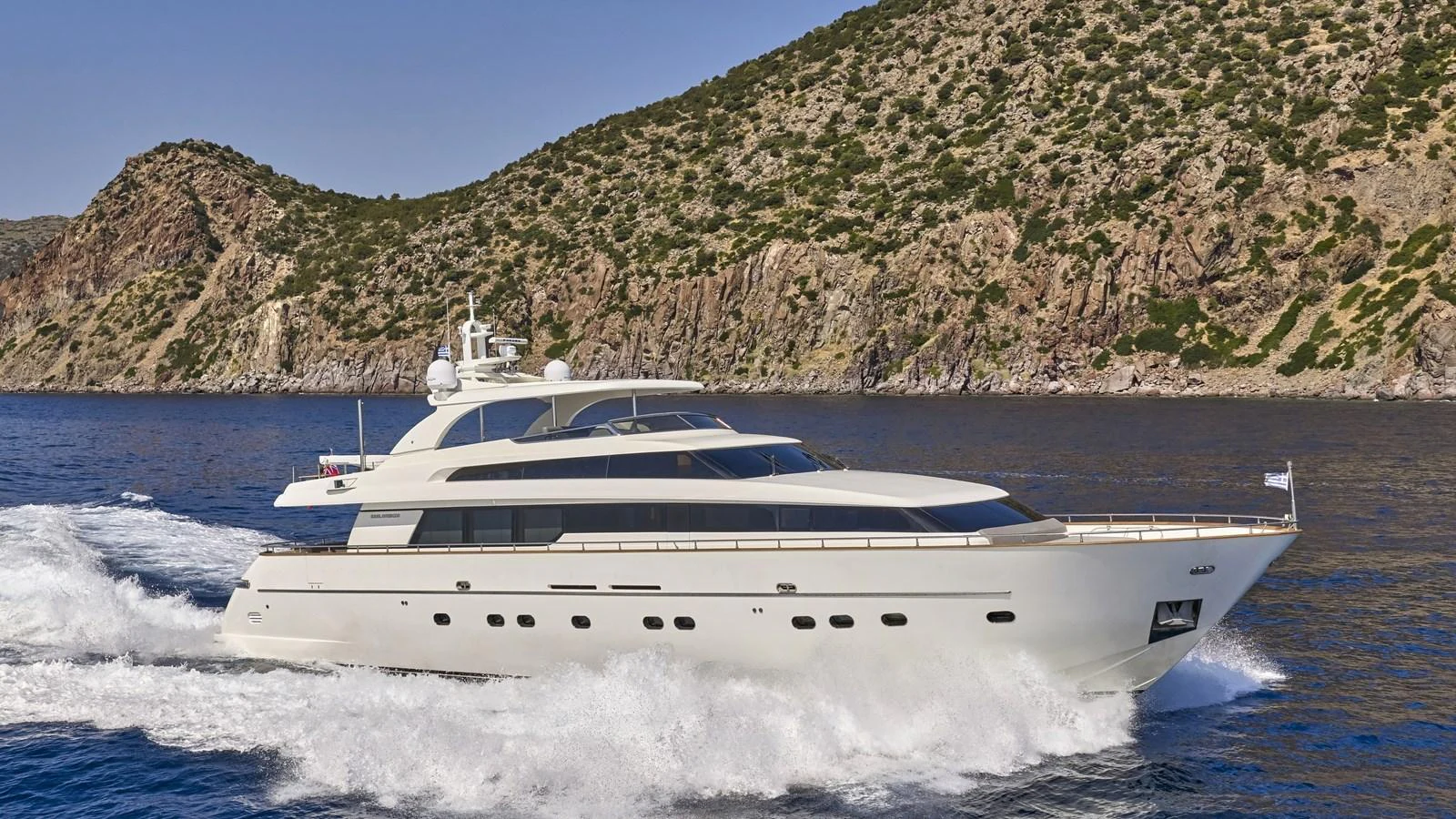 A sleek yacht cruises along the coastline, showcasing its elegant design. aboard OASIS Yacht for Sale