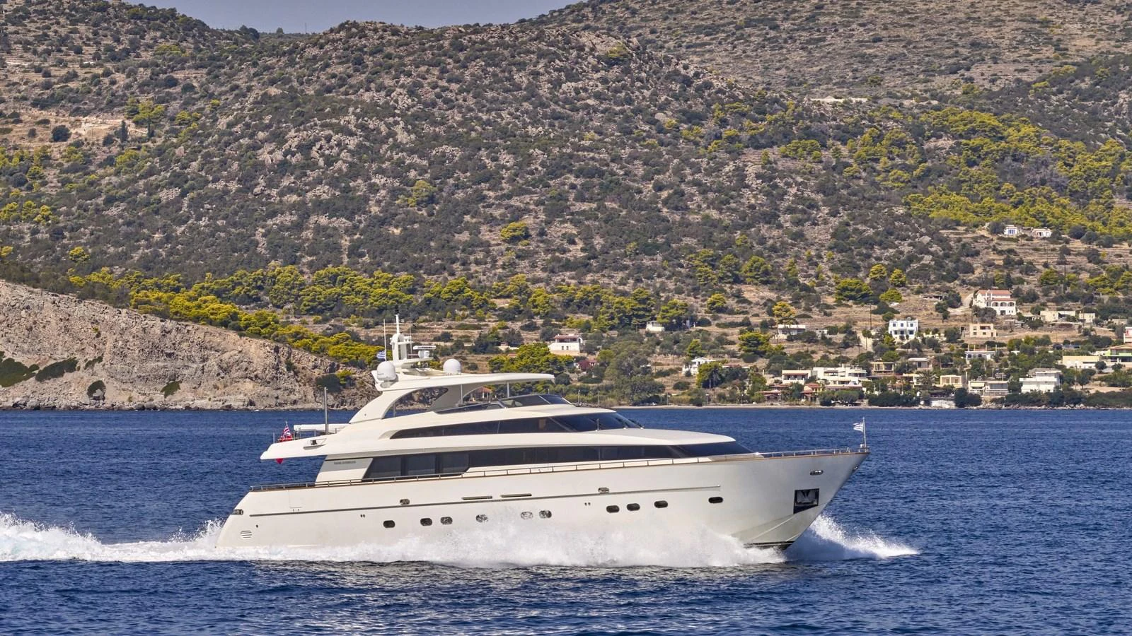 A sleek yacht cruises along the coastline, showcasing its elegant design against a scenic backdrop. aboard OASIS Yacht for Sale