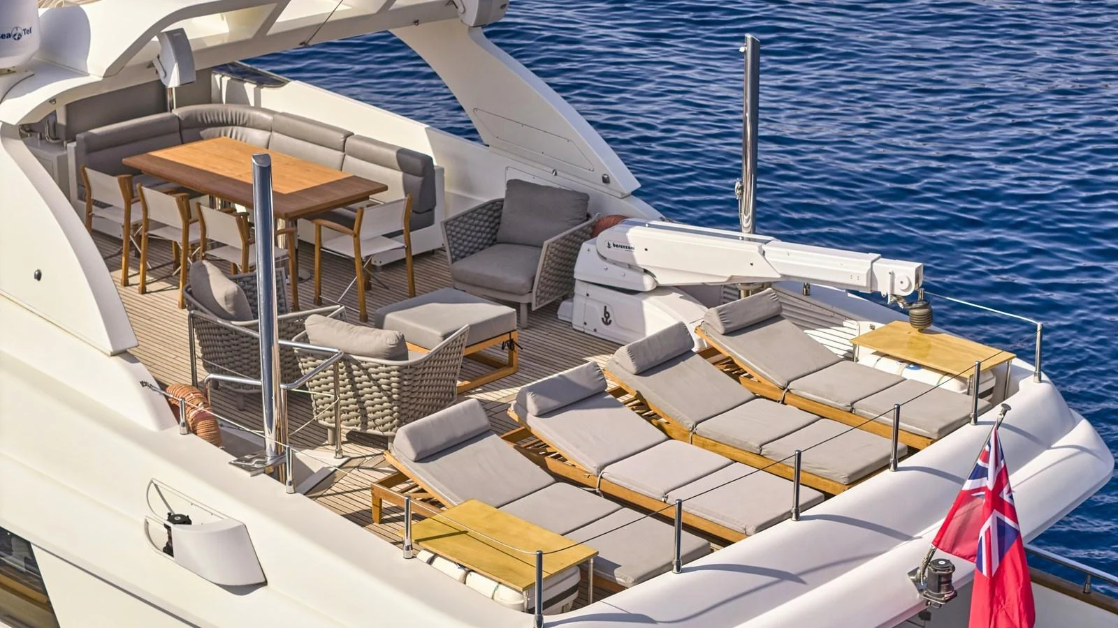 The aft deck features a spacious lounging area with sunbeds and a dining table, perfect for relaxation and socializing. aboard OASIS Yacht for Sale