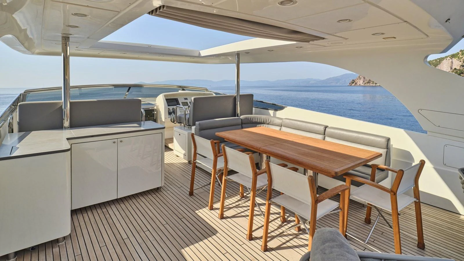 The flybridge offers a spacious and elegant outdoor dining area with stunning sea views. aboard OASIS Yacht for Sale