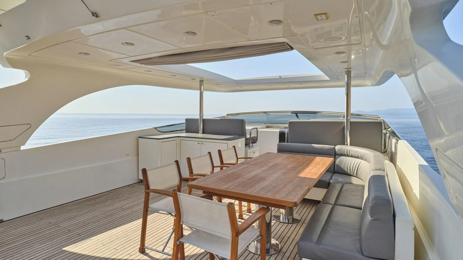 The flybridge offers a spacious and elegant outdoor dining area with stunning sea views. aboard OASIS Yacht for Sale