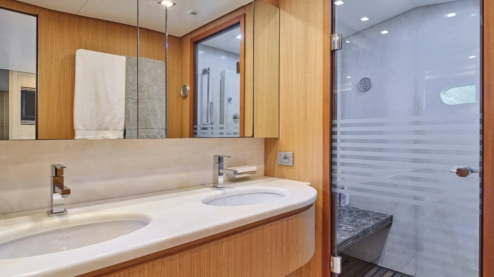 The yacht's bathroom features a double sink vanity and a spacious shower area with modern fixtures. aboard OASIS Yacht for Sale