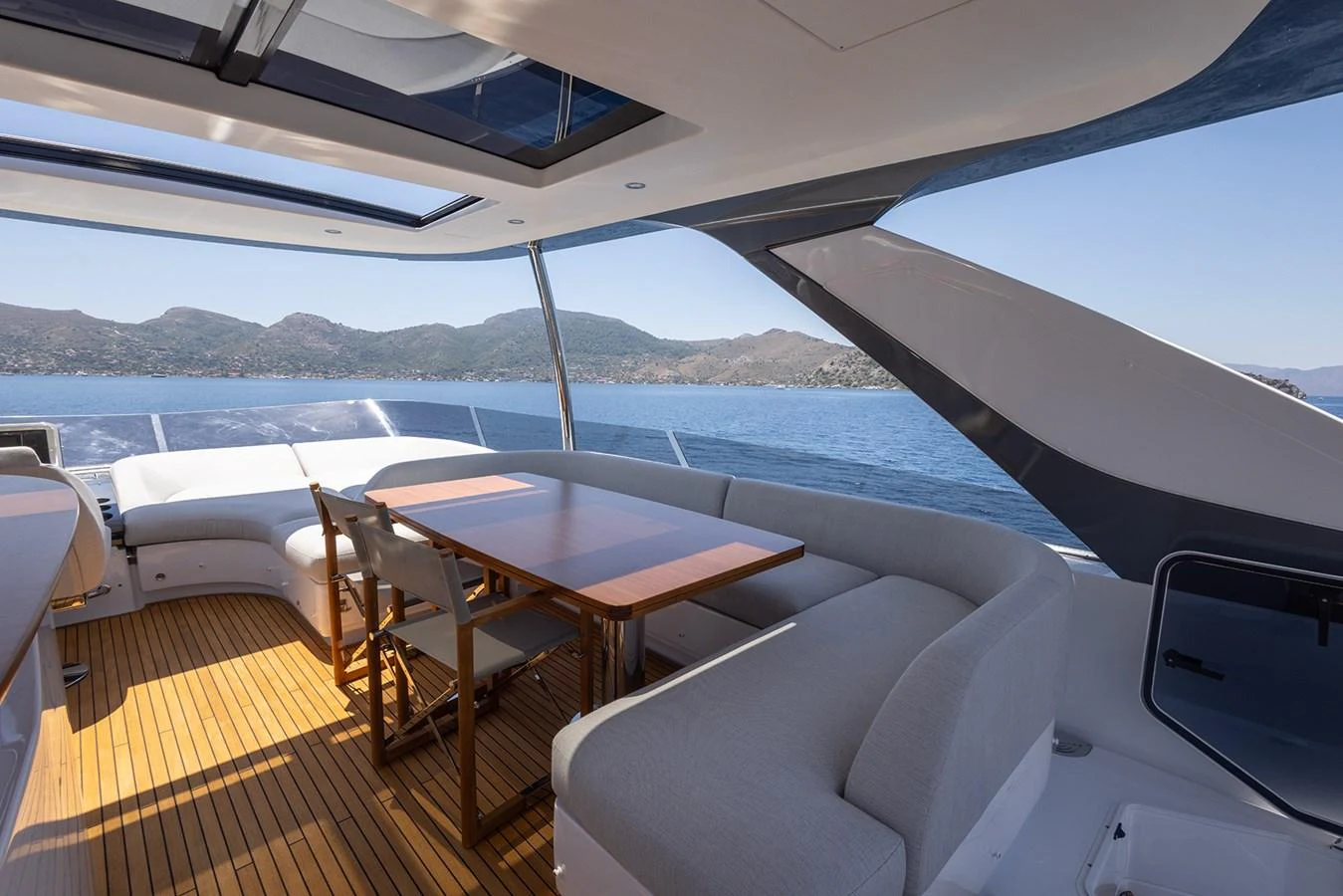 The flybridge offers a spacious seating area with a dining table, perfect for enjoying meals with a view. aboard MILES Yacht for Sale