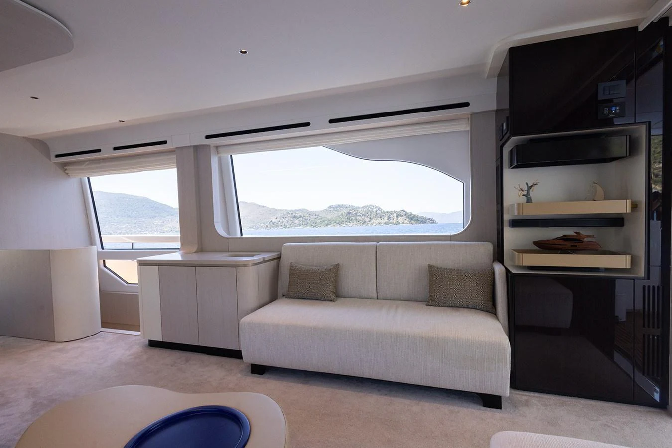 The salon features a comfortable seating area with large windows offering scenic views. aboard MILES Yacht for Sale