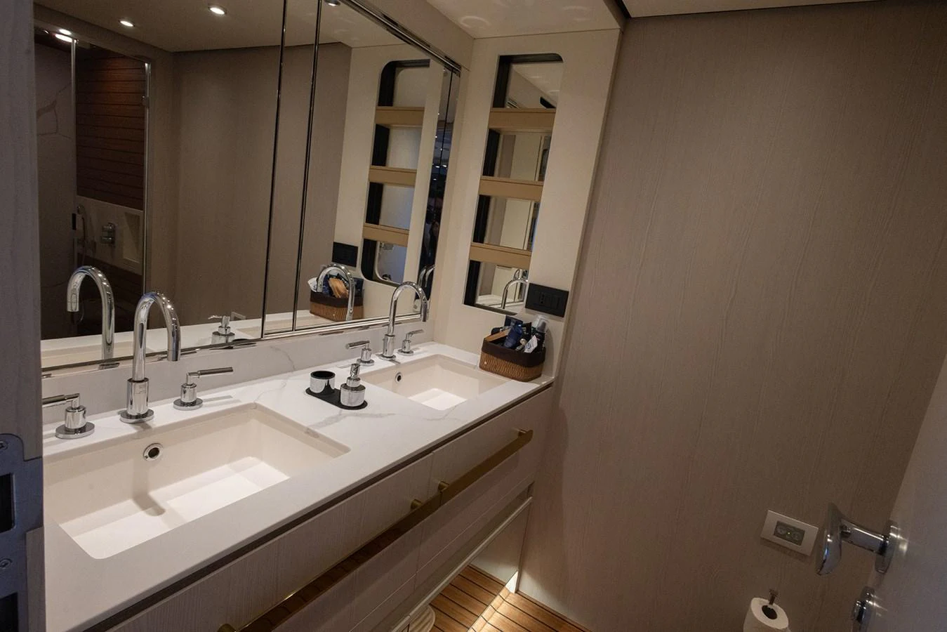 This image showcases a modern and elegant yacht bathroom with dual sinks and ample lighting. aboard MILES Yacht for Sale
