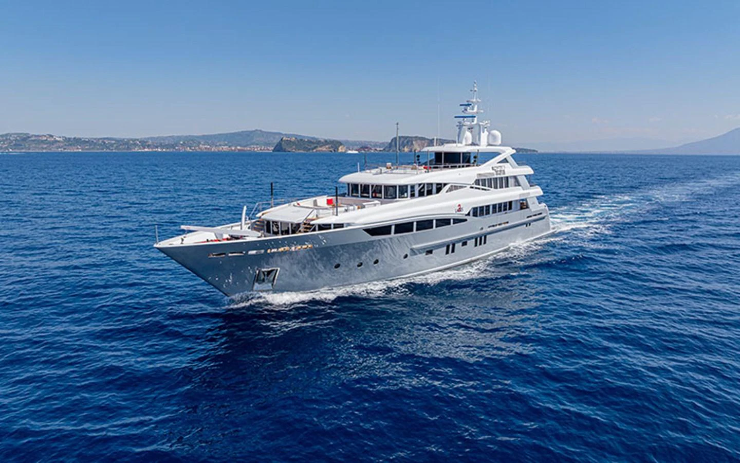 A luxurious yacht cruises through clear blue waters under a bright sky. aboard 2 LADIES Yacht for Sale
