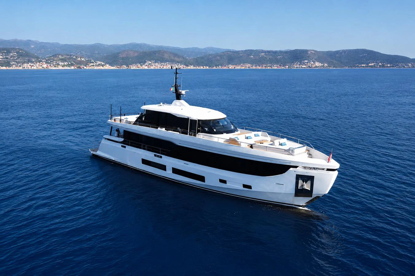 A sleek and modern yacht cruising on calm blue waters with a scenic coastal backdrop. aboard COME TOGETHER Yacht for Sale