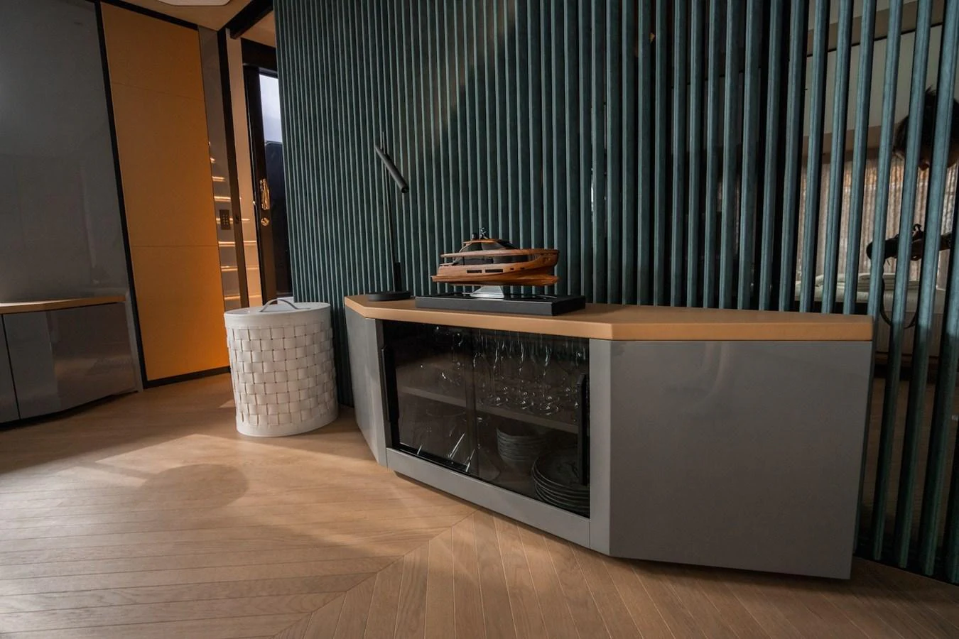 A stylish interior space featuring a modern sideboard with a yacht model on top and a unique cylindrical storage unit. aboard COME TOGETHER Yacht for Sale