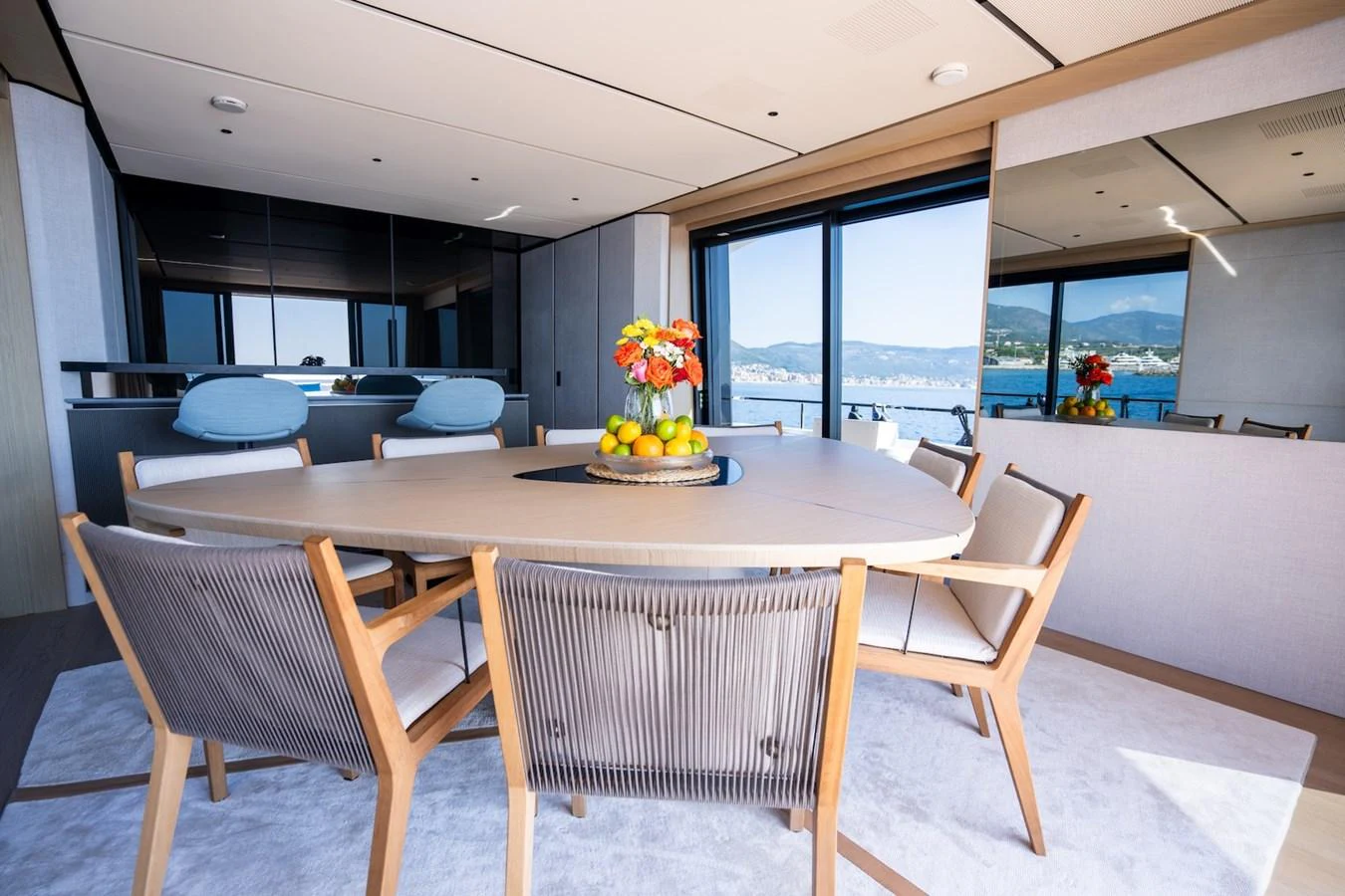 The yacht's dining area features a modern table with comfortable seating and large windows offering scenic views. aboard COME TOGETHER Yacht for Sale