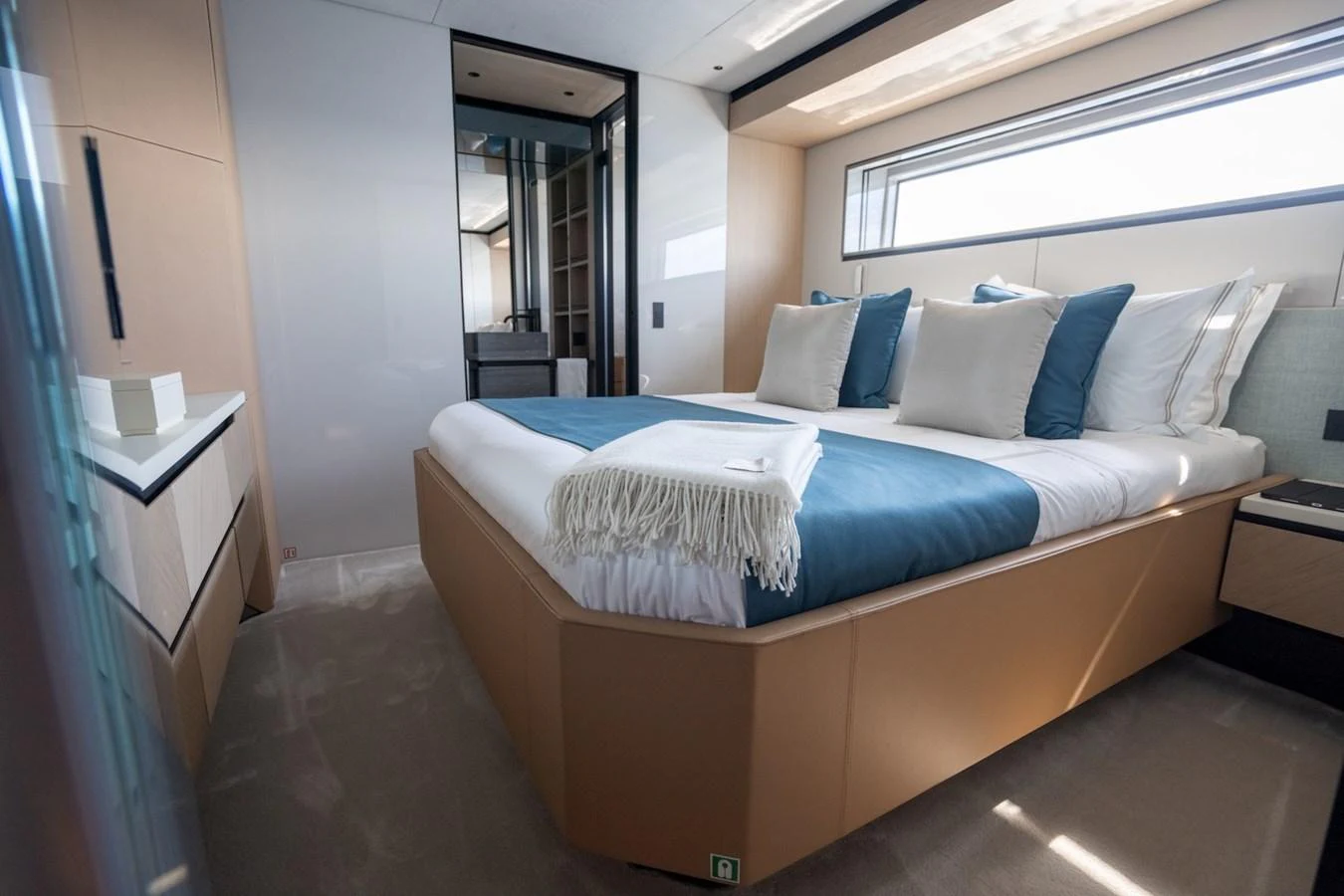 The stateroom features a luxurious bed with elegant bedding and ample natural light. aboard COME TOGETHER Yacht for Sale
