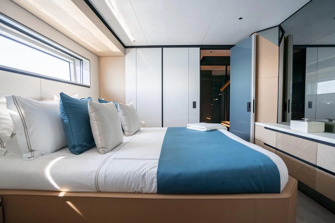 The stateroom features a luxurious bed with plush pillows and modern cabinetry. aboard COME TOGETHER Yacht for Sale