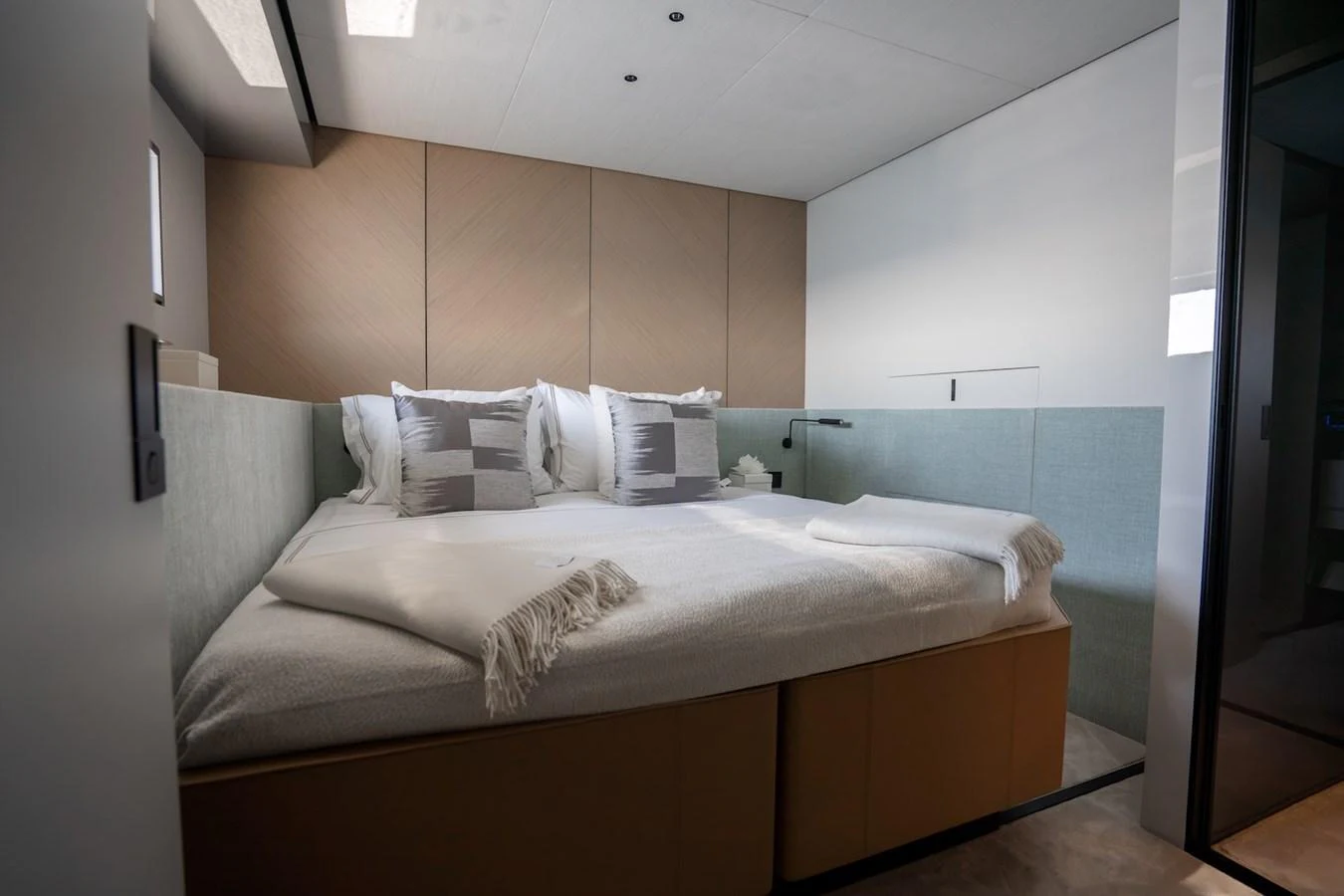 The stateroom features a cozy bed with plush pillows and a modern, minimalist design. aboard COME TOGETHER Yacht for Sale