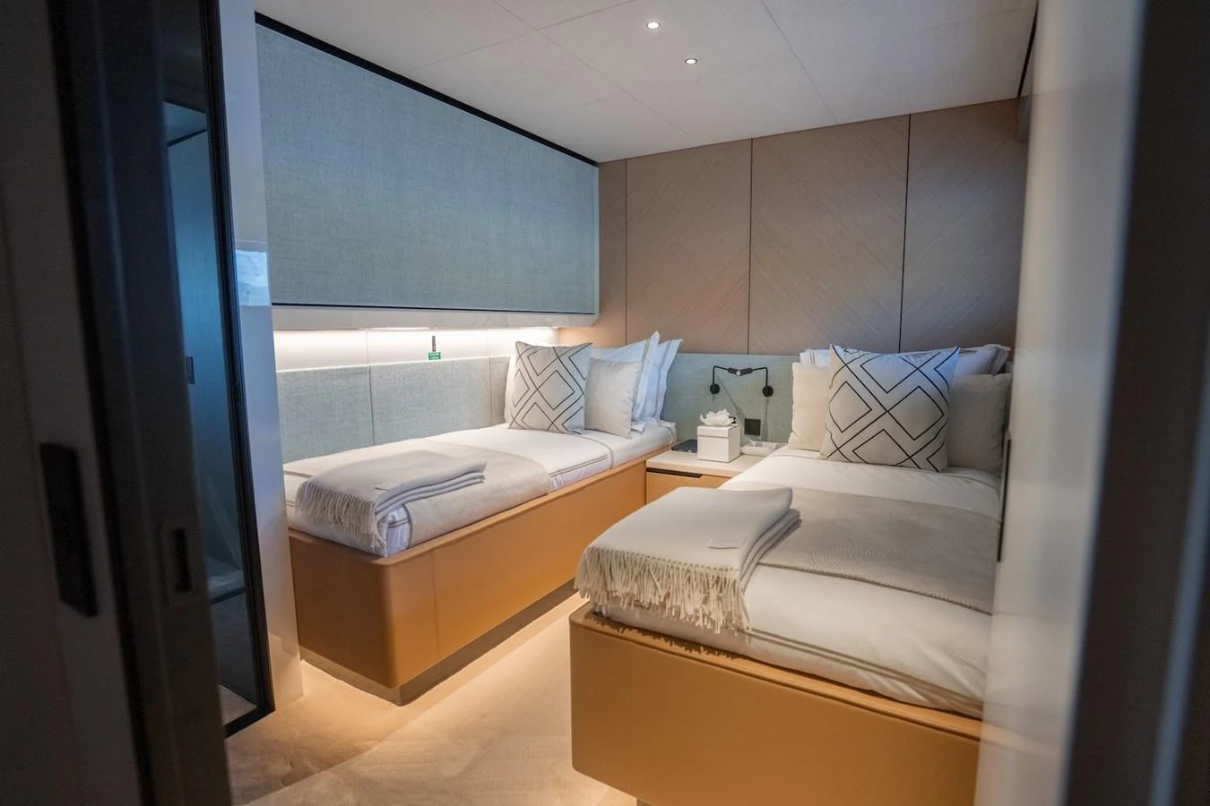 The guest stateroom features twin beds with elegant bedding and modern decor. aboard COME TOGETHER Yacht for Sale