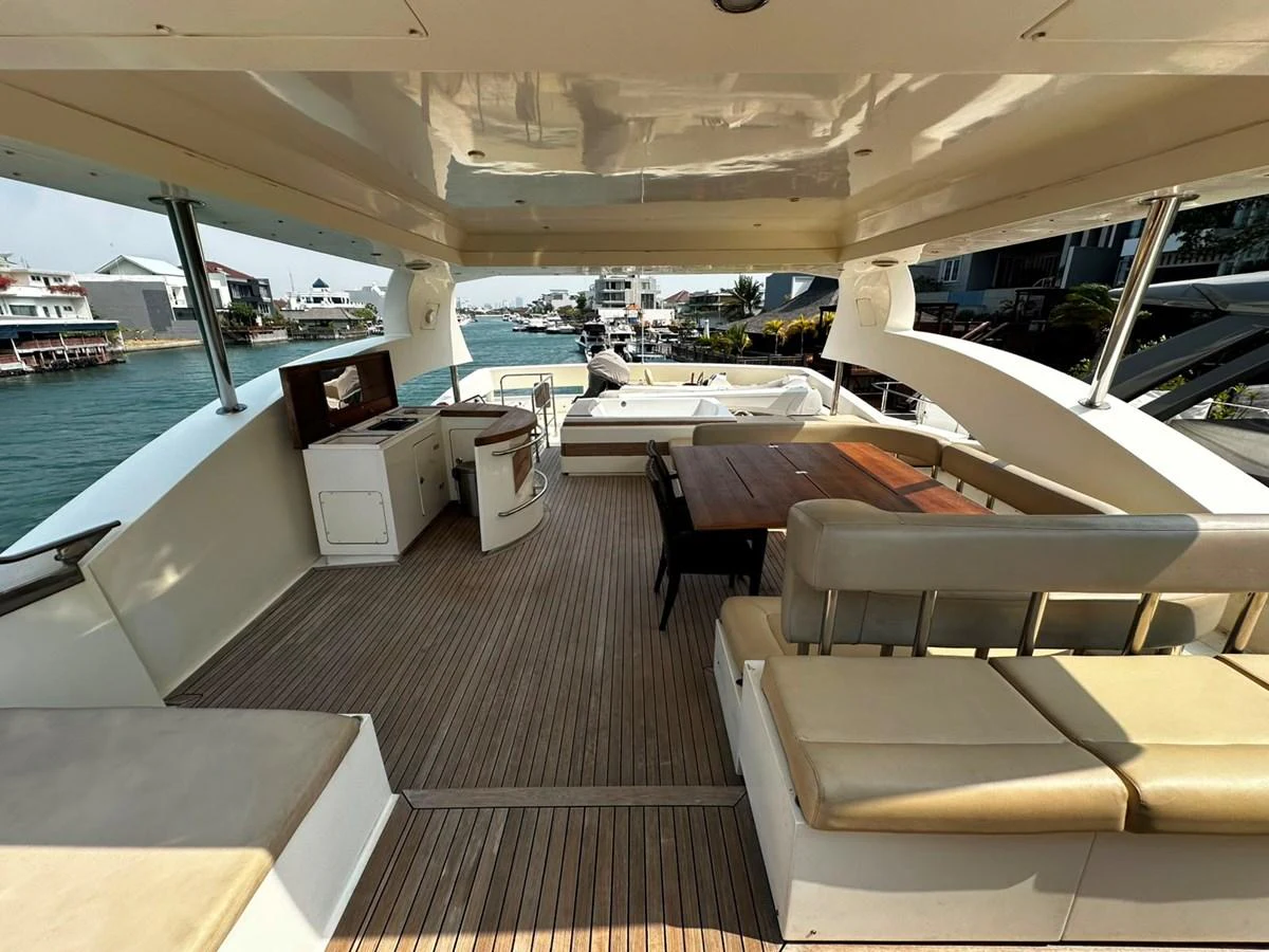 The aft deck features a spacious seating area with a wooden table, perfect for outdoor dining and relaxation. aboard GALLEN Yacht for Sale