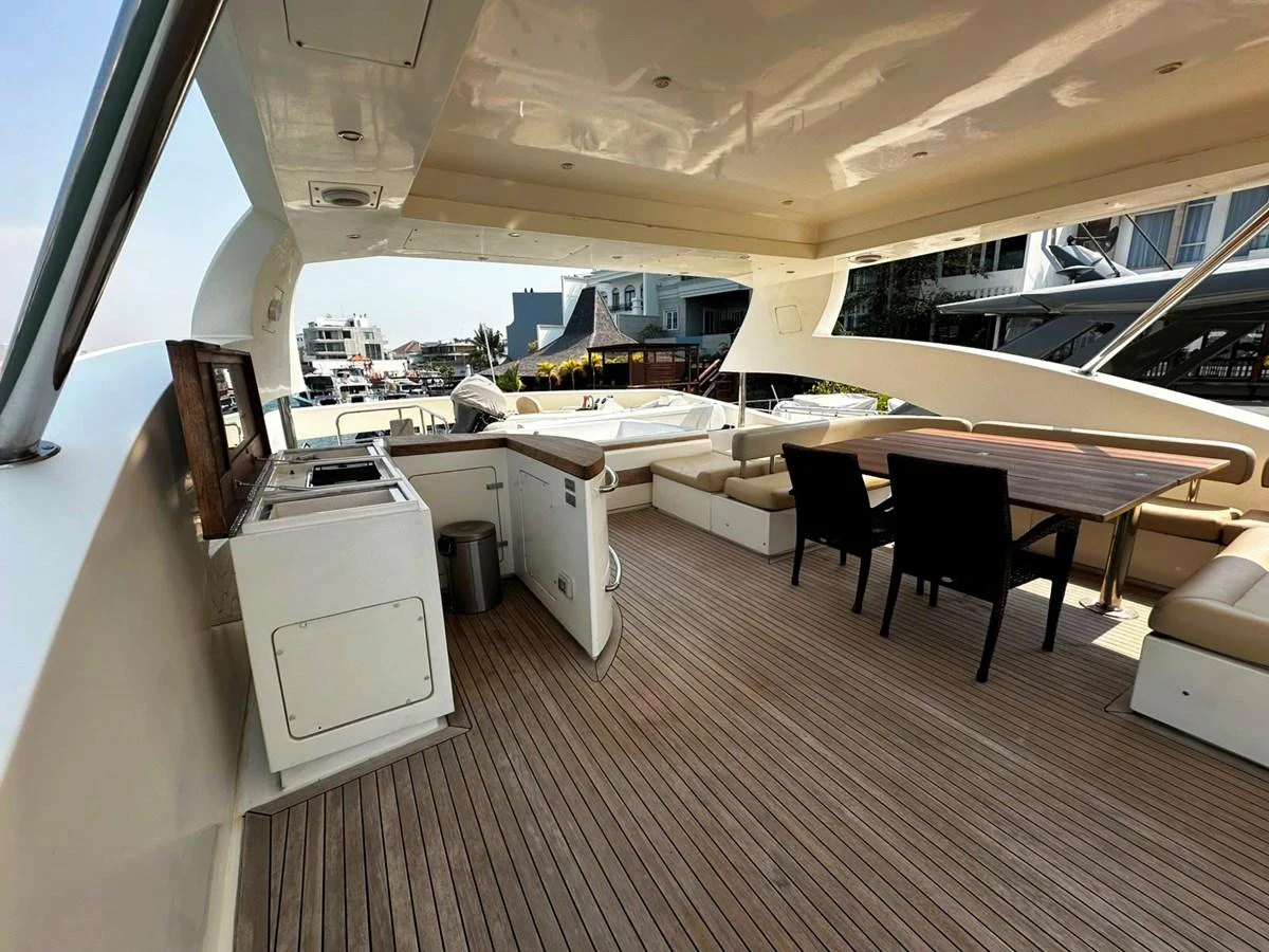 The aft deck features a spacious seating area with a dining table and a small kitchenette, perfect for outdoor entertaining. aboard GALLEN Yacht for Sale