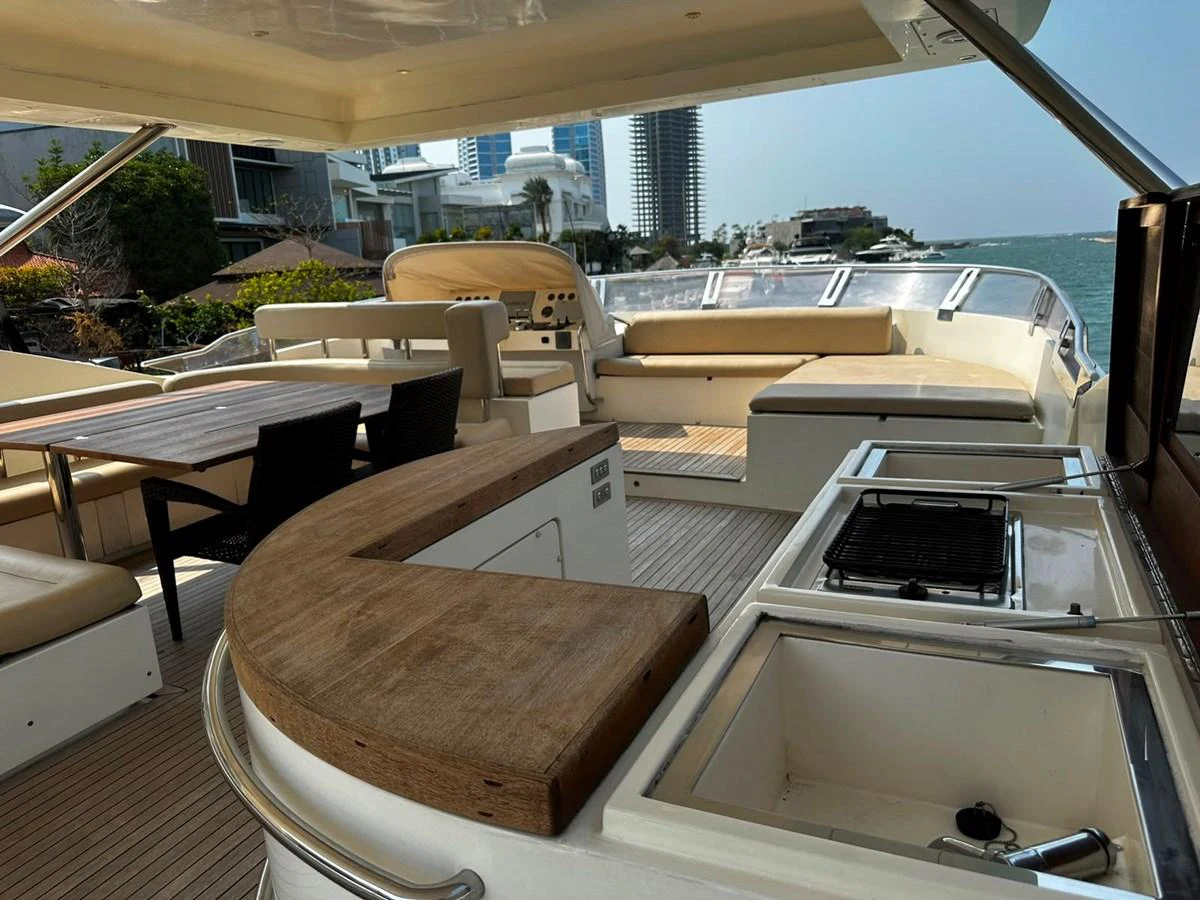 The flybridge offers a spacious area with a dining table, seating, and a grill, perfect for outdoor entertainment. aboard GALLEN Yacht for Sale
