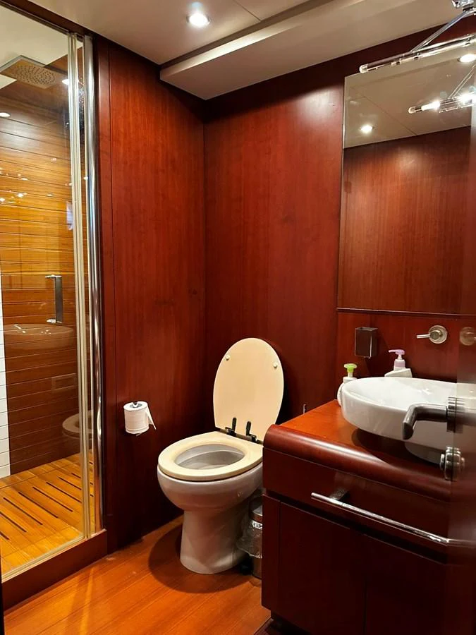 A well-appointed yacht bathroom with wooden finishes and modern fixtures. aboard GALLEN Yacht for Sale