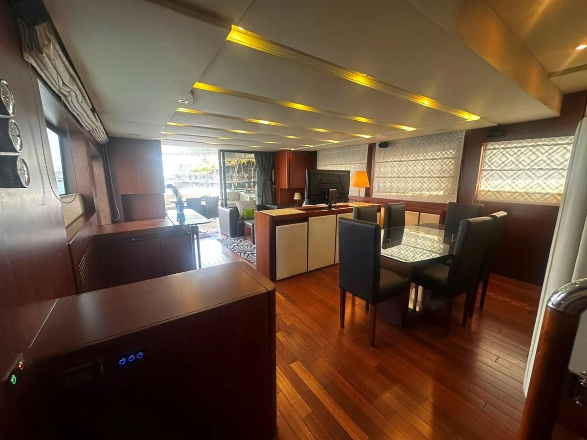 The yacht's salon features elegant wood flooring, comfortable seating, and a dining area with a sophisticated ambiance. aboard GALLEN Yacht for Sale