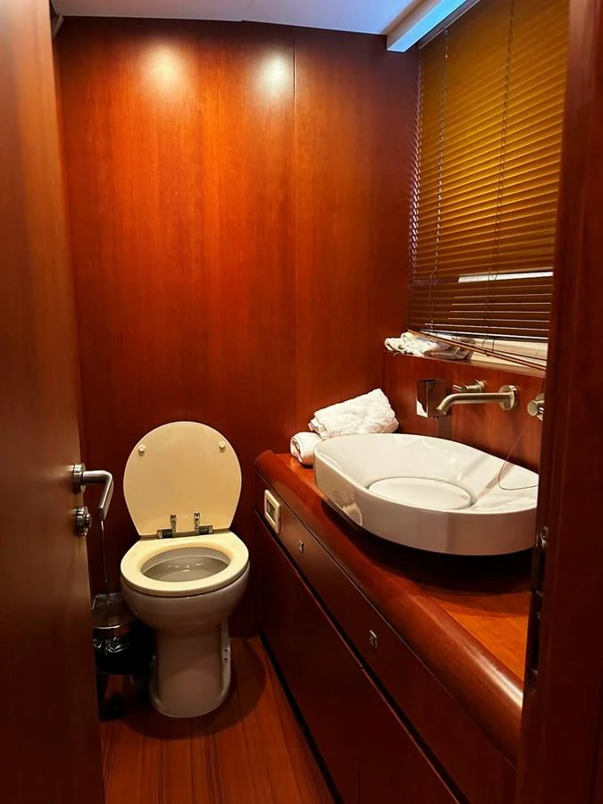 The yacht's head features elegant wood paneling and modern fixtures, providing a luxurious and private space. aboard GALLEN Yacht for Sale