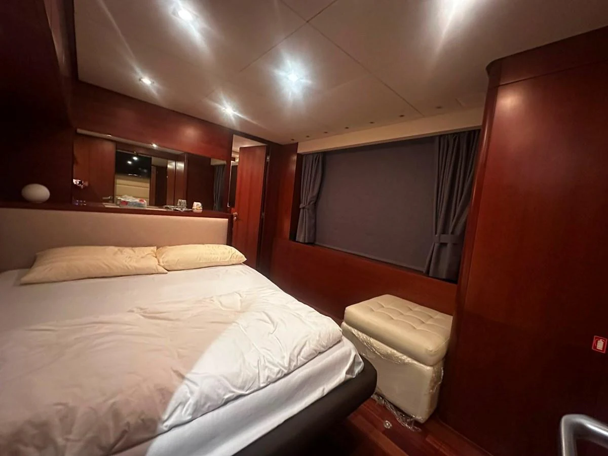 The stateroom features a cozy bed with elegant wooden paneling and soft lighting. aboard GALLEN Yacht for Sale