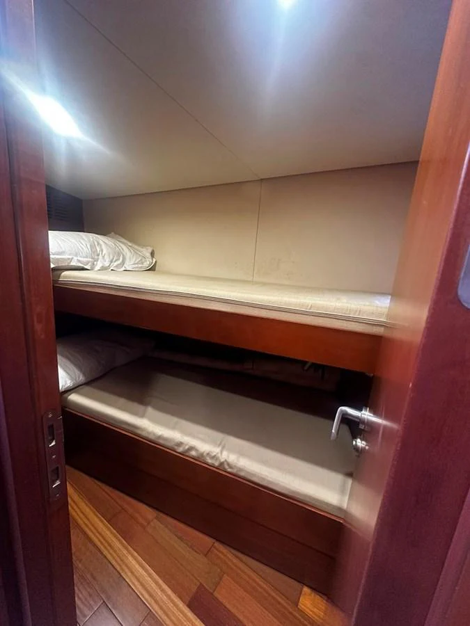 A cozy bunk cabin with wooden finishes and soft lighting. aboard GALLEN Yacht for Sale
