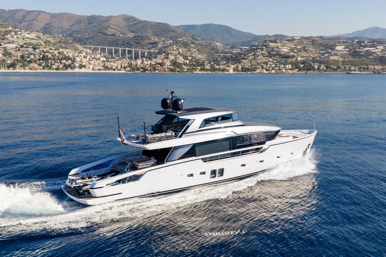 A sleek and modern yacht cruises along the coastline, showcasing its elegant design and spacious decks. aboard JUNIOR Yacht for Sale