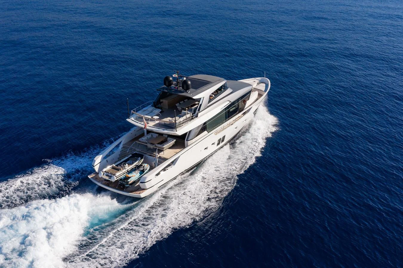 A sleek yacht cruises through the open sea, showcasing its modern design and spacious deck. aboard JUNIOR Yacht for Sale
