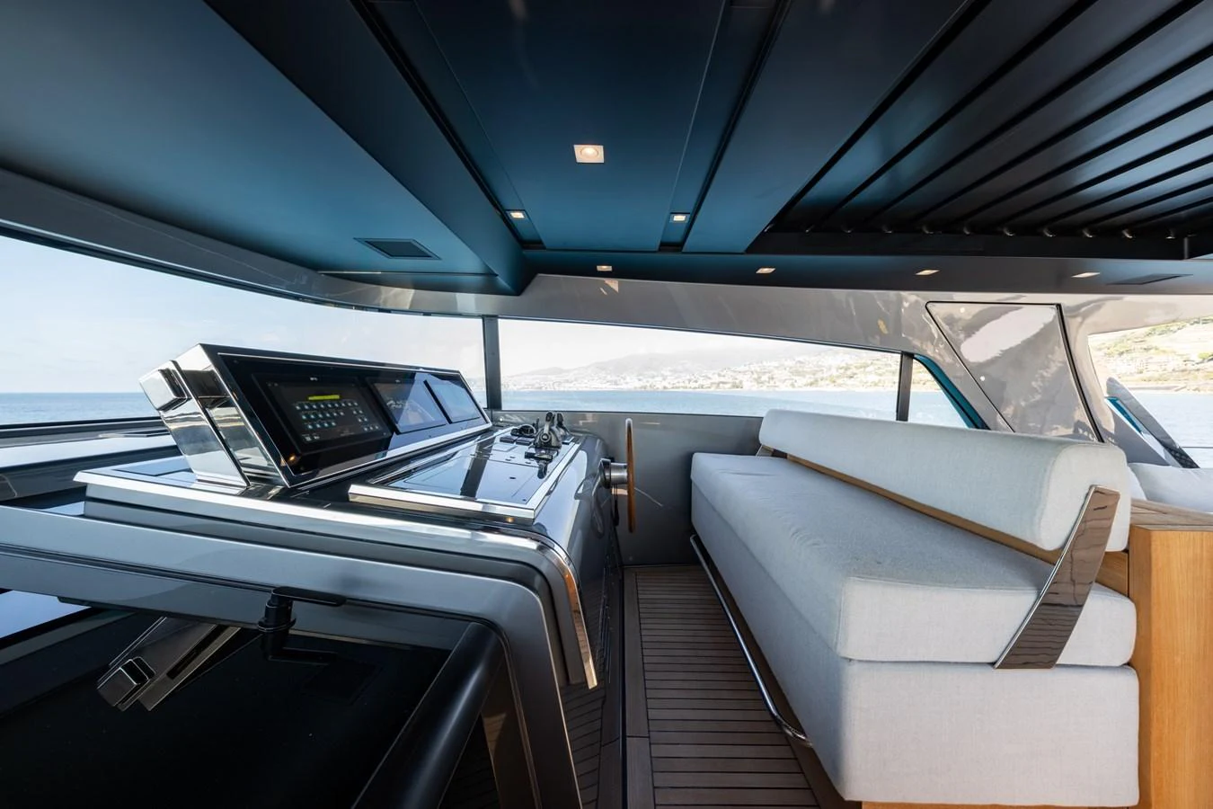 The helm area features modern controls and a comfortable seating arrangement with panoramic views. aboard JUNIOR Yacht for Sale